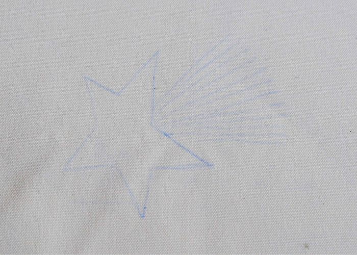 Segni di trasferimento del modello con carta di trasferimento blu su tessuto bianco